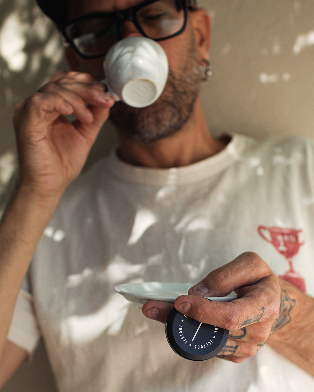 Icetool Mini Can Black — held by a person drinking from a small white cup.